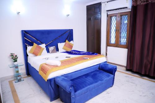 a large bed with a blue headboard in a room at Divine India Service Apartment 1bhk, D-198,UGF in New Delhi