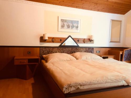una camera con un grande letto con testiera in legno di Holmes Café & Pension a Engelhartszell