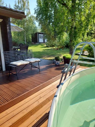 a wooden deck with a bench on top of it at Kotoisa mökki Kangasniemellä in Kangasniemi