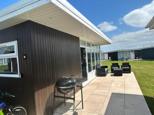een zwart gebouw met een grill op een patio bij Beautiful Chalet, 18 Cordova, Selsey Country Club in Selsey