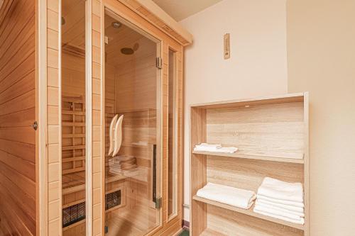 y baño con ducha, armarios de madera y toallas. en Pool House Mržek Family Friendly - Happy Rentals en Nova Vas