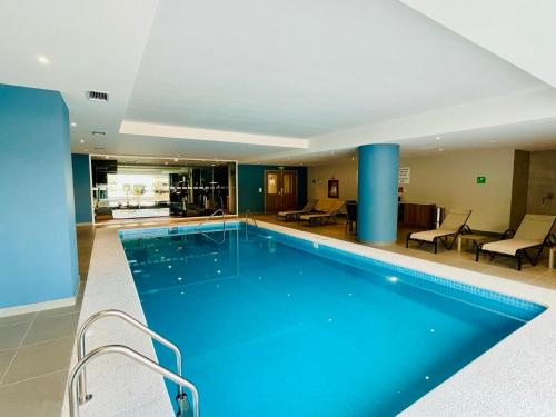 a large swimming pool in a hotel with blue columns at Holiday Inn Express - Guadalajara Vallarta Poniente, an IHG Hotel in Guadalajara