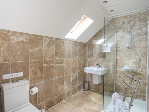 a bathroom with a shower and a toilet and a sink at The Old Coal Yard in Cemaes Bay