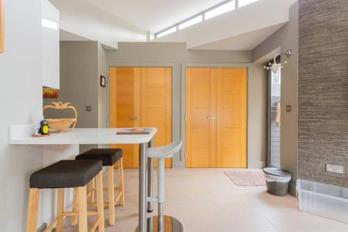 a kitchen with a table and stools in a room at The Studio House - Crouch End in London