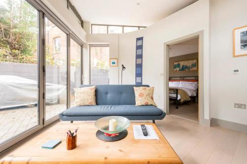 a living room with a blue couch and a table at The Studio House - Crouch End in London