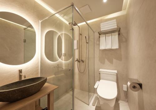 La salle de bains est pourvue d'un lavabo, de toilettes et d'une douche. dans l'établissement UH Suite Central Seoul, à Séoul