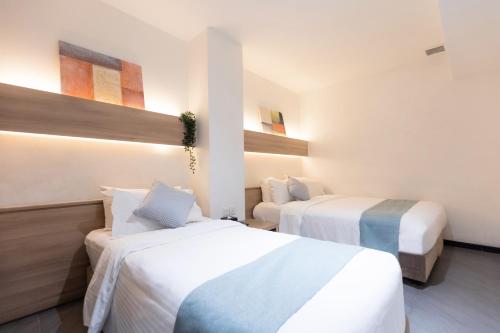 a hotel room with two beds in a room at Hotel NuVe in Singapore