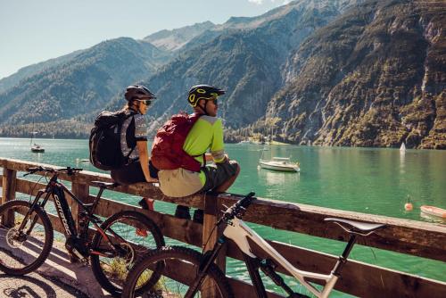 two men are sitting on a fence with their bikes at Hotel St. Georg zum See in Maurach