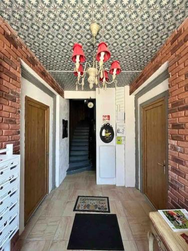 un couloir avec un lustre et un mur en briques dans l'établissement Le nid douillet, à Le Mont-Dore
