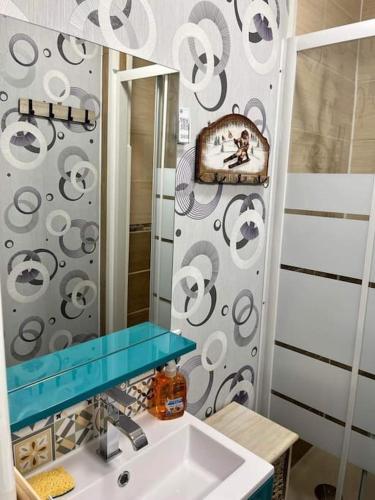 une salle de bain avec un lavabo et un miroir dans l'établissement Le nid douillet, à Le Mont-Dore