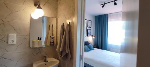 Lapegle في آلوكسني: حمام مع مغسلة وسرير في الغرفة