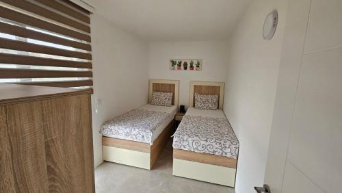 2 camas individuales en una habitación con escalera en Apartments Val Maslina, en Utjeha