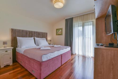 een slaapkamer met een groot bed en een flatscreen-tv bij Apartment Marija Bibinje Zadar in Bibinje
