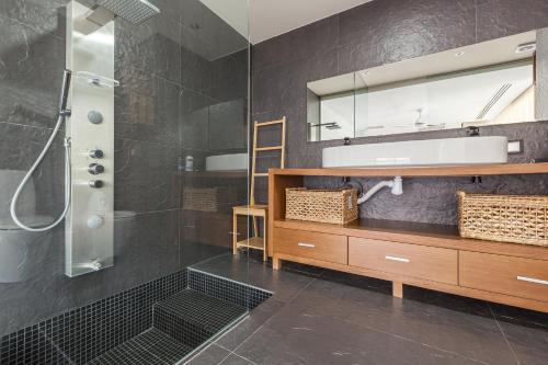een badkamer met een douche, een wastafel en een spiegel bij Espai Oliveres in Papiol