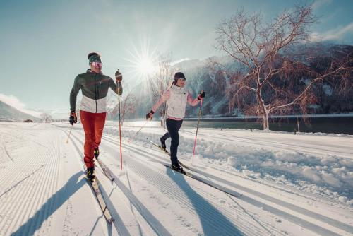 two people cross country skiing in the snow at Hotel St. Georg zum See in Maurach