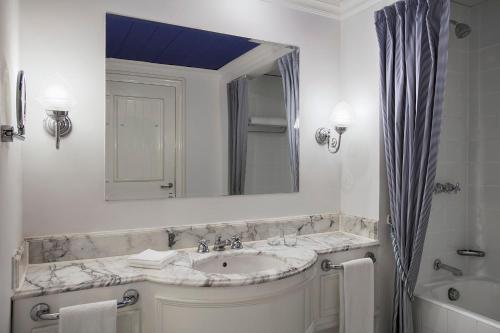een witte badkamer met een wastafel en een spiegel bij Sheraton Sharm Hotel, Resort, Villas & Spa in Sharm El Sheikh