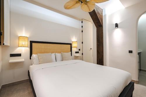 een slaapkamer met een wit bed en een plafondventilator bij Oso Madrid Studios in Madrid