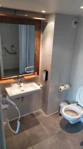 y baño con lavabo, aseo y espejo. en Campanile Clermont-Ferrand Sud Issoire en Issoire