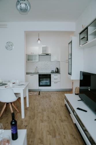 a kitchen with white cabinets and a white table at Apartman Nikola in Gospić