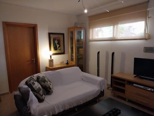 a living room with a couch and a television at Cozy apartment close to the sea in Perea