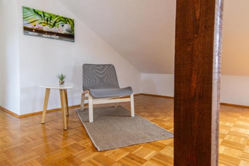 a chair and a table in a room at Lions Apartments - Erholung und Vergnügen in Bad Tatzmannsdorf in Jormannsdorf