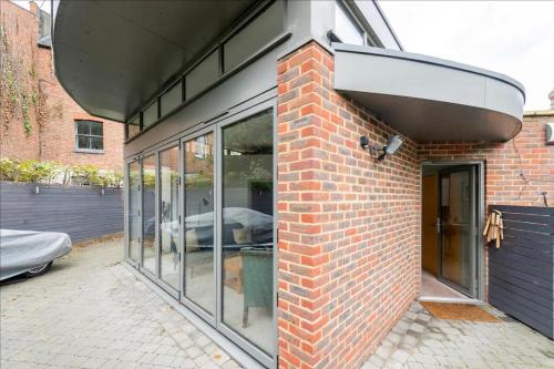 a brick building with glass windows on the side of it at The Studio House - Crouch End in London