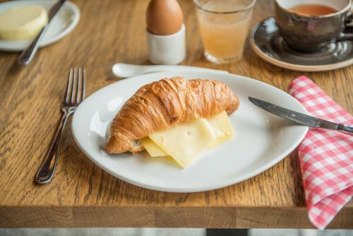 a plate with a croissant and cheese on a table at Erfgoed Bossem in Lattrop