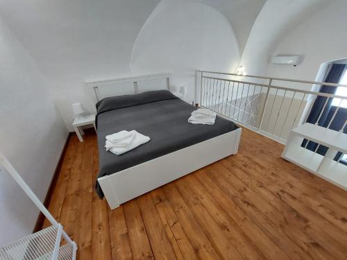Schlafzimmer mit einem Bett und Holzboden in der Unterkunft Casa vacanze Mezzanine in Catania
