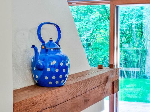 a blue vase sitting on a wooden shelf next to a window at Jakob Cabin in Bovec
