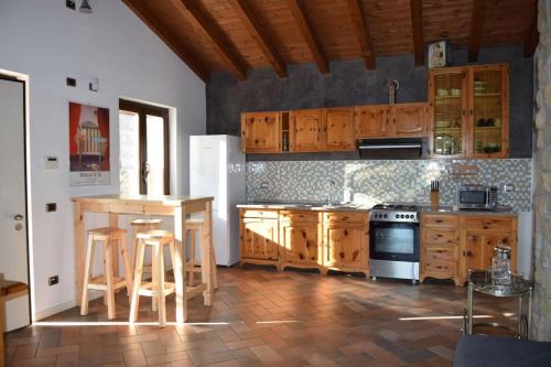 een keuken met houten kasten en een witte koelkast bij Villetta in collina Casa Calmàs in Brione