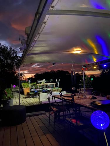 une terrasse avec une table et des chaises sous une tente dans l'établissement Chambre d'hôte insolite sur une péniche, à Portiragnes