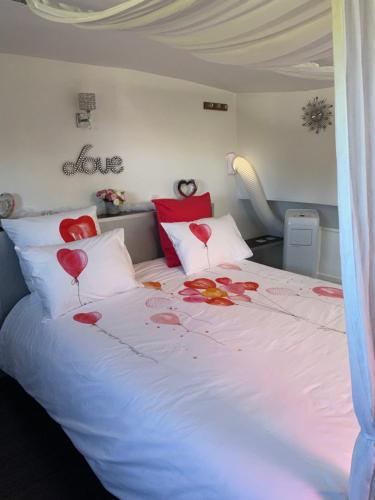 - une chambre avec un lit doté de coeurs rouges sur les oreillers dans l'établissement Chambre d'hôte insolite sur une péniche, à Portiragnes