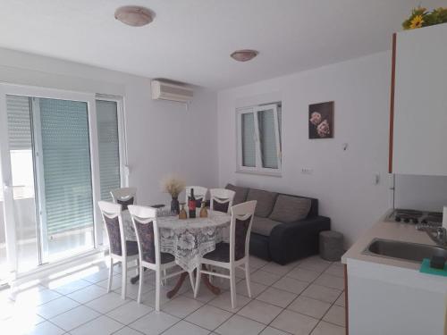 a living room with a table and chairs and a couch at Apartments Boris in Baška Voda