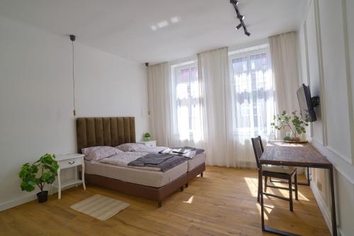 1 dormitorio con cama, mesa y escritorio en Apartament Mieszka I - Śródmieście, en Gorzów Wielkopolski