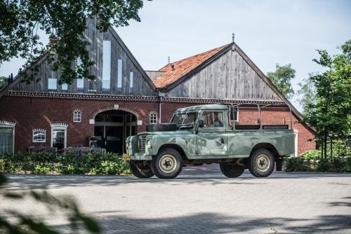 an old green truck parked in front of a building at Erfgoed Bossem in Lattrop