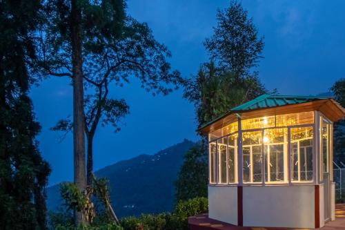 a tiny house in a forest at night at StayVista's Tree Tops & Tea Trails - Mountain-View Villa Amidst Tea Plantation with Telescope & Gazebo in Darjeeling