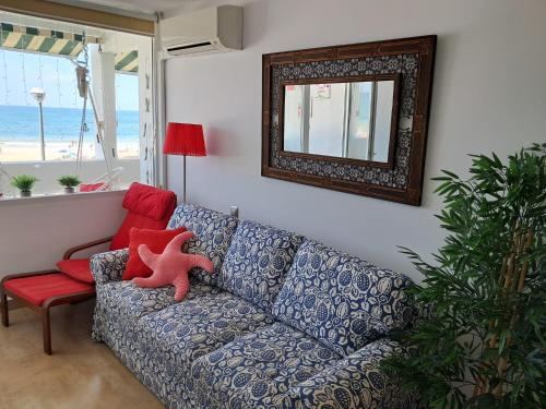 een woonkamer met een bank en een spiegel bij Apartamento 108 Hotel Flamero in Matalascañas
