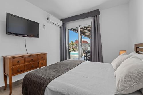 een slaapkamer met een bed, een televisie en een balkon bij Villa Patos in Playa Blanca