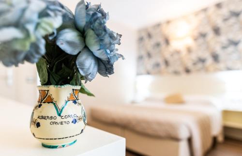 a vase filled with blue flowers sitting on a table at Hotel Corso in Orvieto