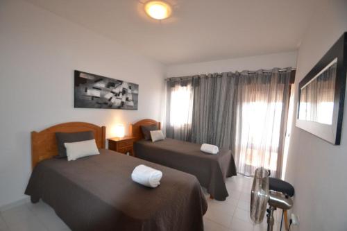 een hotelkamer met twee bedden en een raam bij T3 Olhos de Água in Albufeira