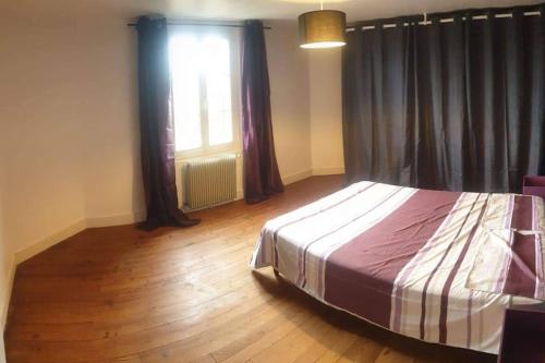 - une chambre avec un lit, du parquet et une fenêtre dans l'établissement Maison lumineuse & jardin privé, à Confolens