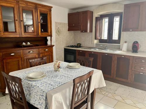 una cucina con tavolo e tovaglia bianca di Housalento a Francavilla Fontana