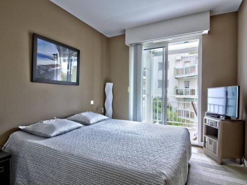une chambre avec un lit, une télévision et une fenêtre dans l'établissement Appartement T2 en Bord de Mer à Arcachon - Plage Privée, Parking, Balcon et WIFI - FR-1-433-45, à Arcachon