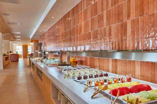 a buffet line with food on display in a restaurant at Universal Aquamarin Beach Houses in Andratx