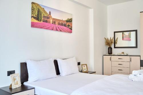 - une chambre blanche avec 2 lits et une commode dans l'établissement Retro Apartment in Infinity Beach Resort, à Mamaia