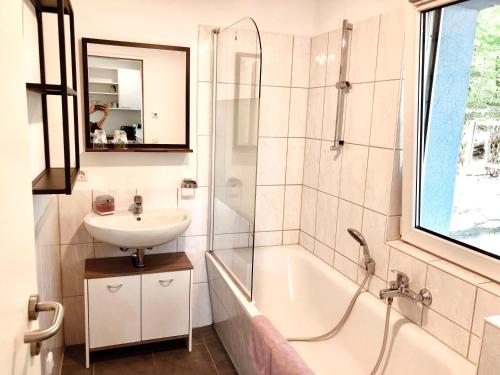 W łazience znajduje się wanna, umywalka i prysznic. w obiekcie Waldschenke Stendenitz Übernachten im Wald am See w mieście Neuruppin
