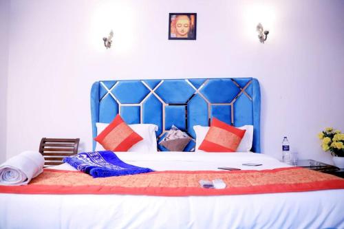 1 dormitorio con 1 cama grande y cabecero azul en Divine India Service Apartment,2Bhk, D-198,SAKET en Nueva Delhi