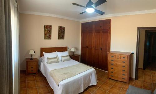 a bedroom with a bed and a ceiling fan at Casa de María in Valle de Abdalagís