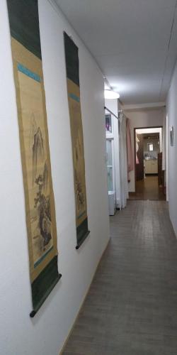 a hallway with three paintings on a wall at 小樽民泊太田1号館 in Otaru