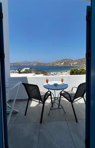 a table and chairs on a patio with a view of the ocean at Princess Sissy in Ios Chora